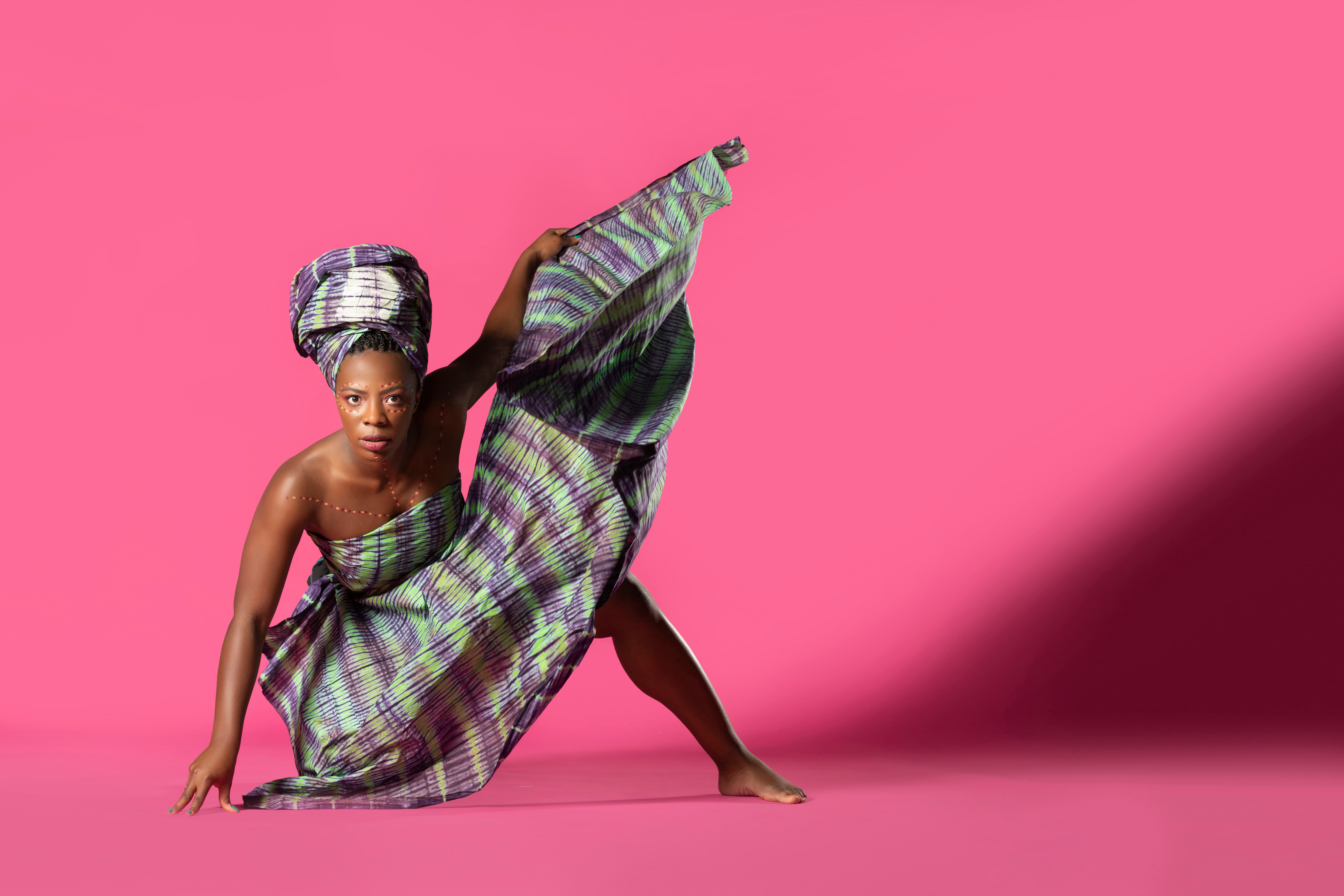 Black woman dancer in bent over pose with background and large shadow