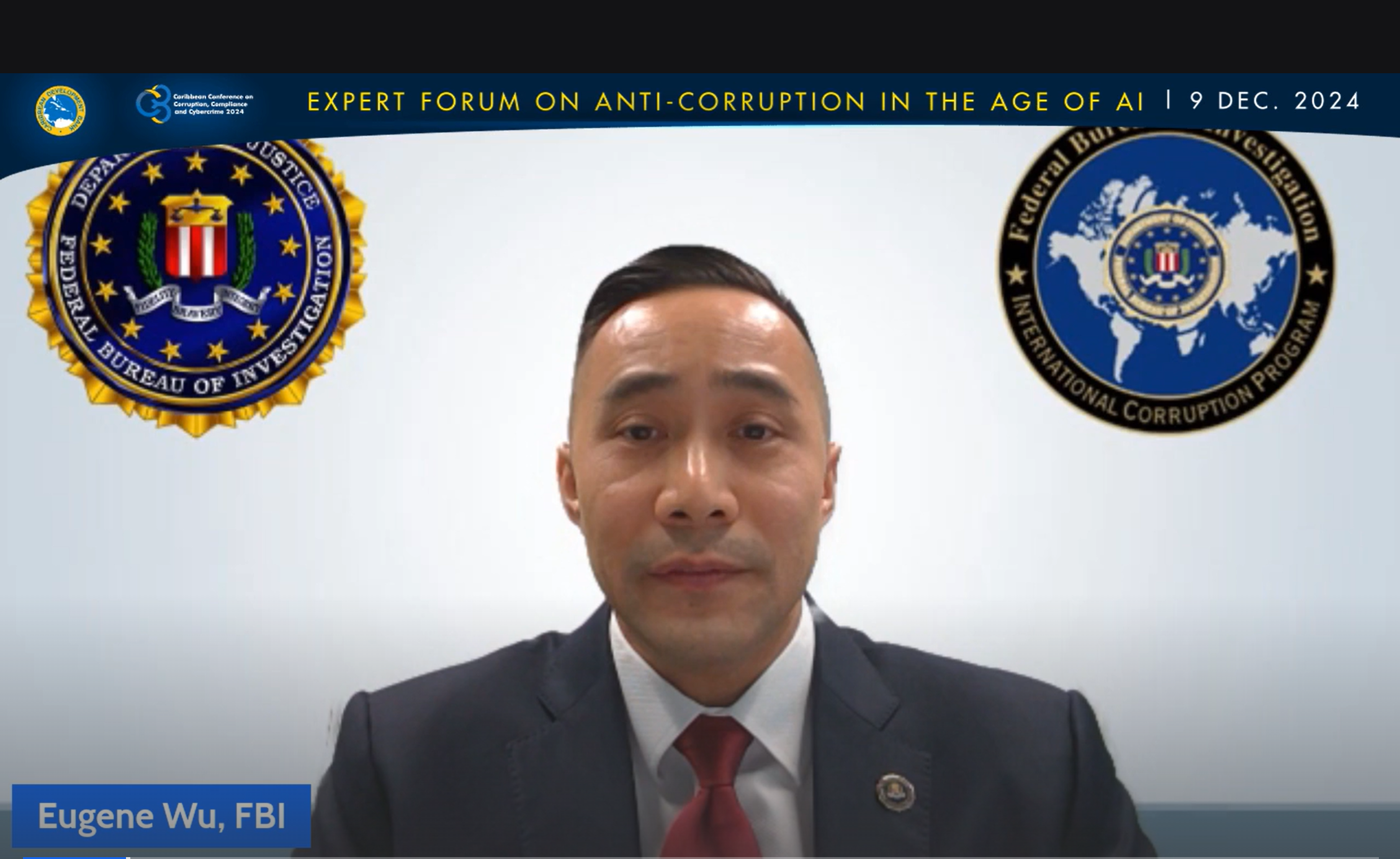 Image of Eugene Wu sitting in front of two logos on a white background