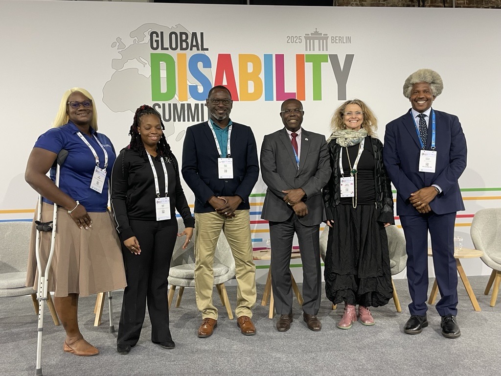 a group of abled bodied and disabled standing together in business attire in room 
