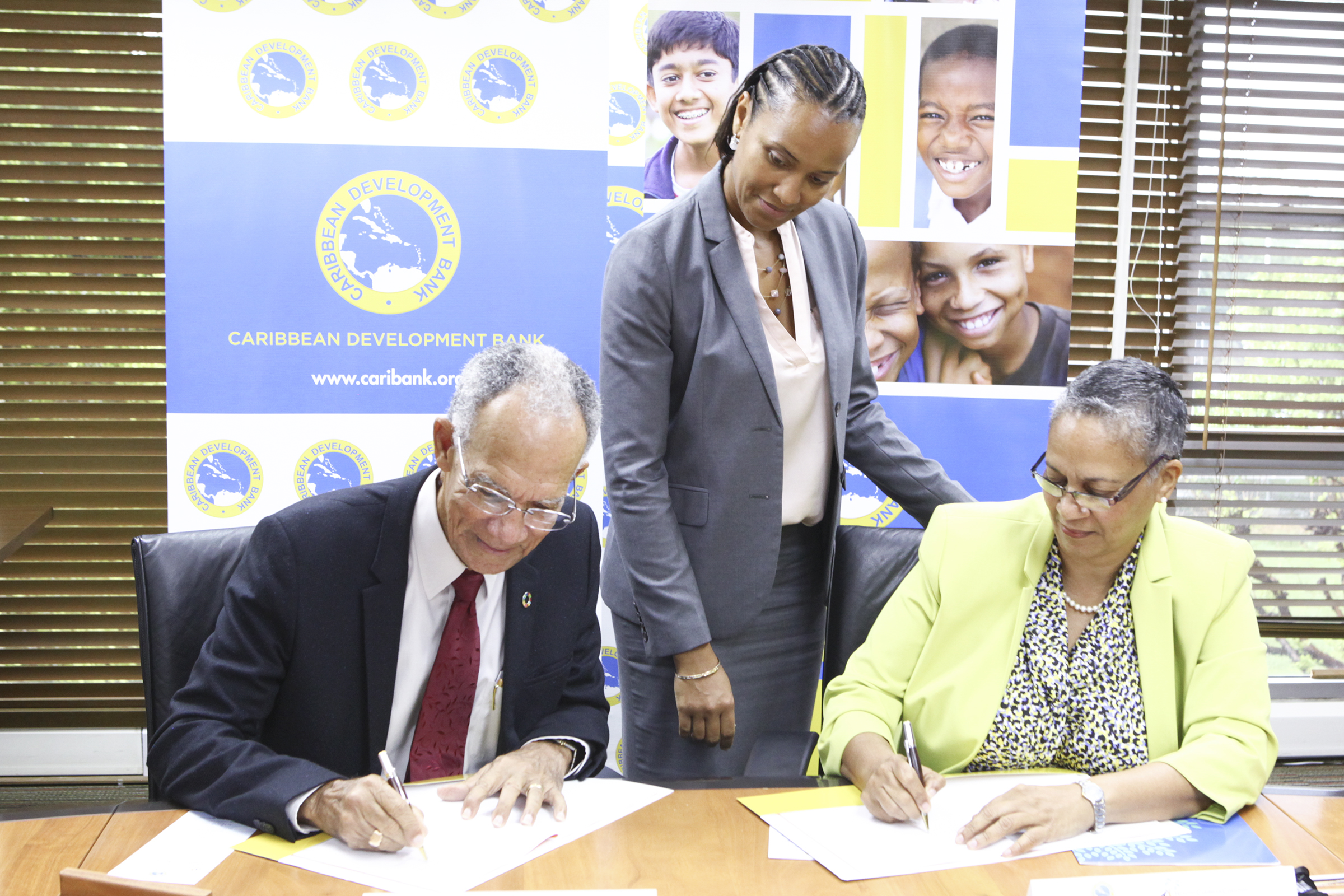 Sir. Trevor Hassell, President of the HCC (left) and Monica La Bennett, Vice-President (Operations), CDB (right) sign the grant agreement in the presence of CDB’s Deputy General Counsel, Nicole Jordan (centre).