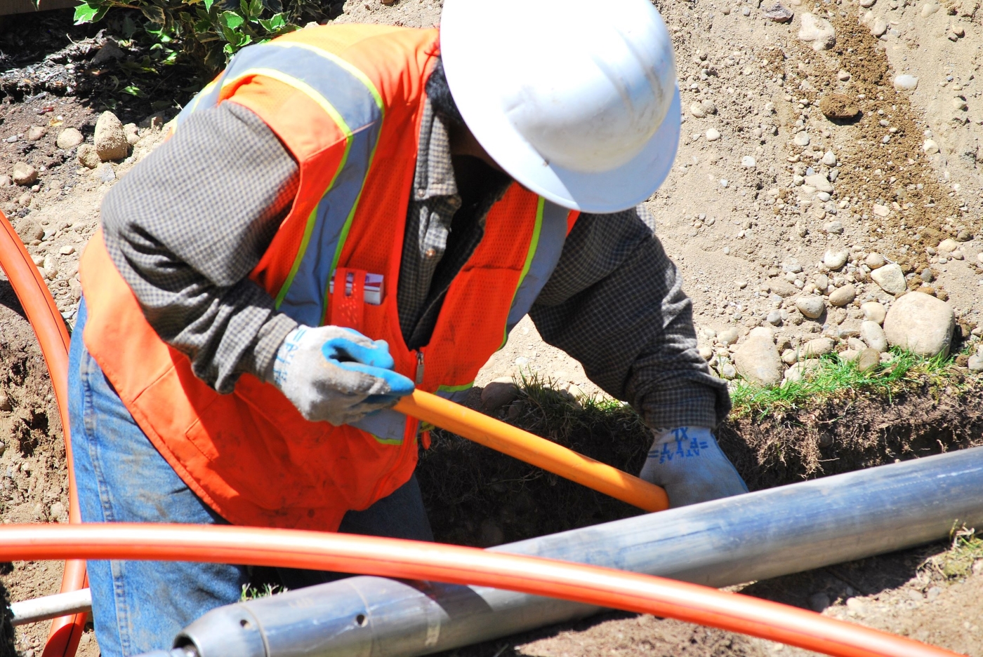 Construction worker measuring pipes
