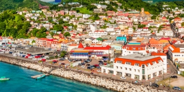 Cover of the 2024 Annual Report for the Office of Independent Evaluation (OIE) at the Caribbean Development Bank. The image features a vibrant waterfront cityscape with colorful buildings, lush green hills, and a clear blue sky. The title 'Annual Report 2024' is prominently displayed in bold blue and yellow text, with the CDB logo and 'Office of Independent Evaluation' at the bottom left corner.