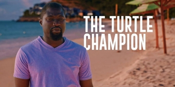 Jepson Prince standing on a sandy beach in a white T-shirt