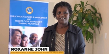 Roxanne John standing in black jacket with stripped inside shirt