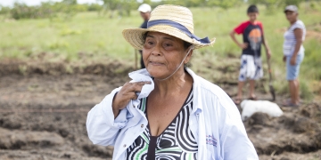 female warmer in the field  wipes away sweat from her face