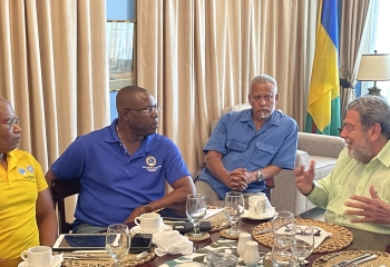 four gentlemen sit facing each other having a discussion